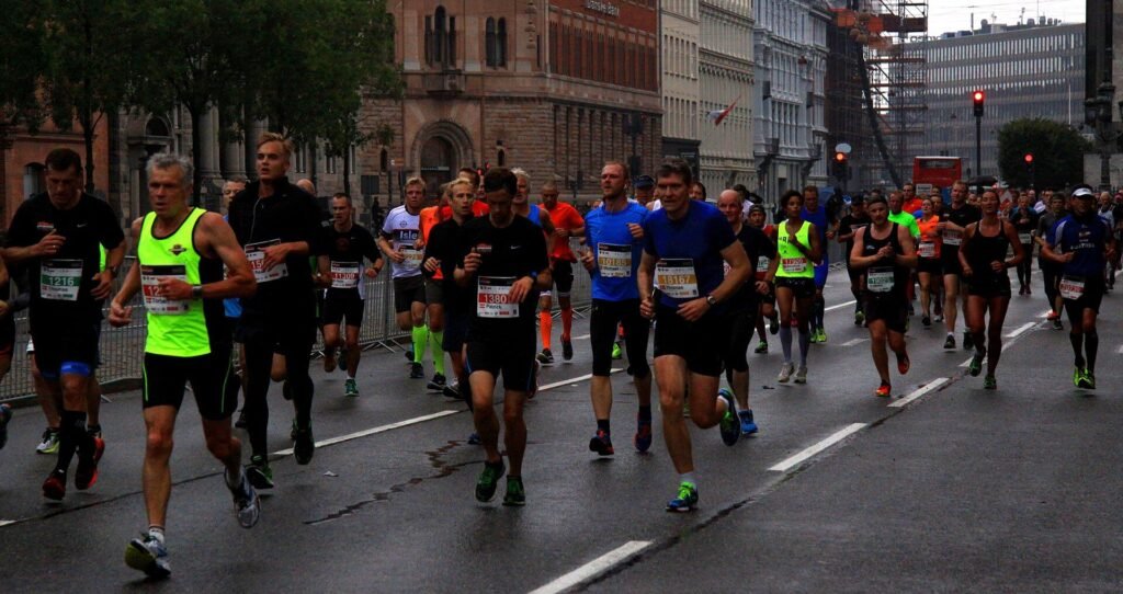 Corredores amadores disputando a meia maratona de Copenhague em rua molhada, cenário do recorde mundial de 2026