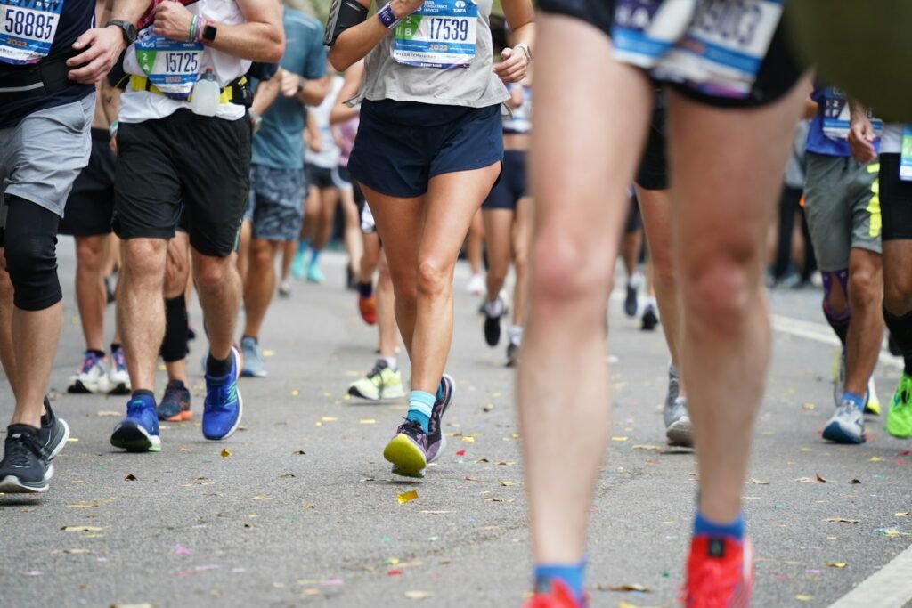 Pelotão de corredores com números de peito durante uma maratona de rua